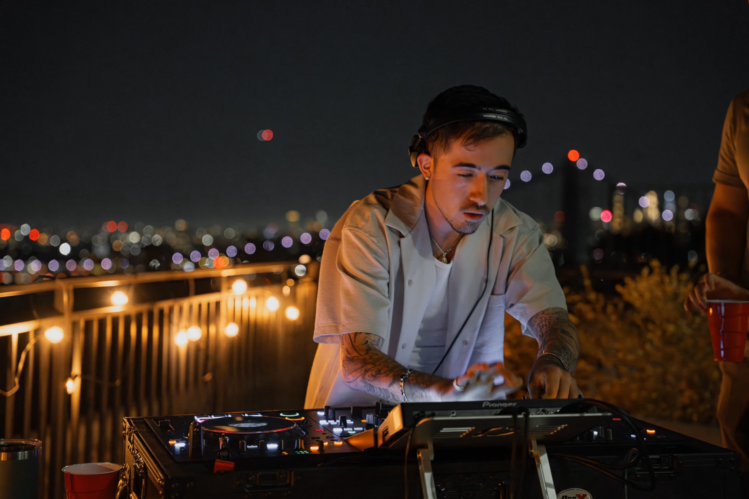 AED performing a DJ set on a New York rooftop at night